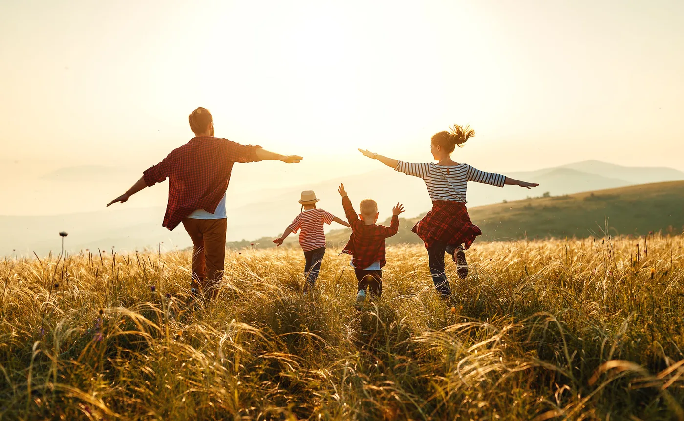 Family running together at sunset